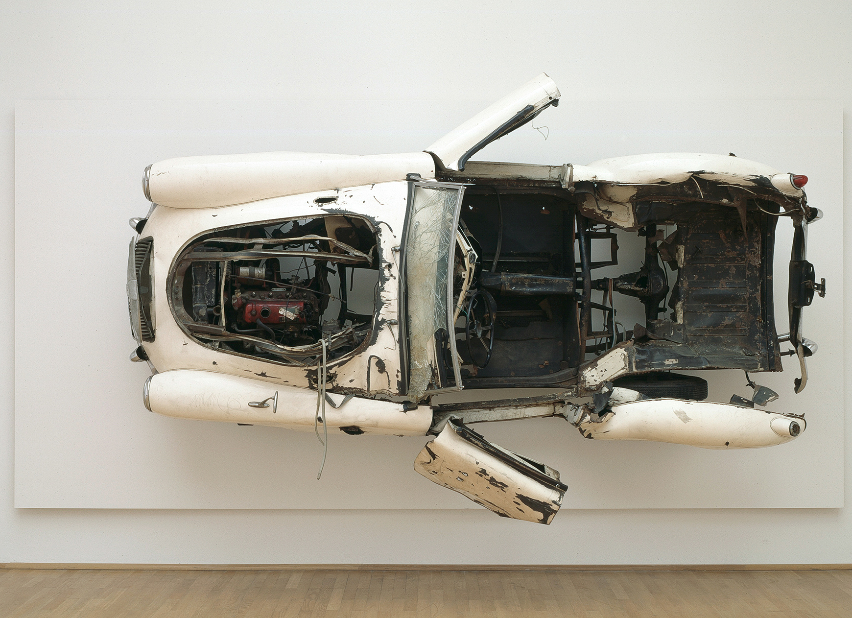 Arman, White Orchid, 1963, exploded MG sports car mounted on wood, 8'2 3⁄8" × 16'8 3⁄4" × 4'3 1⁄8". © Artists Rights Society (ARS), New York / ADAGP, Paris. Photo: Axel Schneider, Museum MMK für Moderne, Frankfurt am Main.